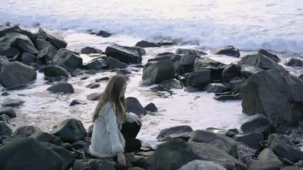 Uma Jovem Senta Praia Admirando Belo Pôr Sol Jogando Seixos — Vídeo de Stock