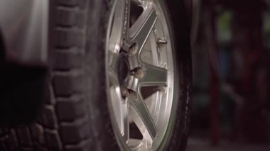 Bir araba tamircisi garaj kutusunda araba lastiği nut.4k,30fps sıkılaştırmak için bir şok anahtarı kullanarak çekleri sıkılaştırır.
