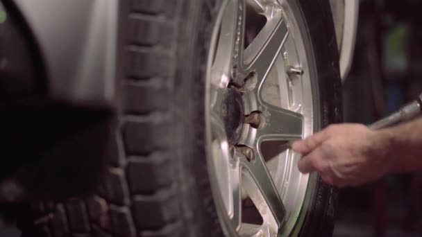 车库箱里的一名汽车修理工用冲击扳手加强检查 以拧紧汽车轮胎的螺母 — 图库视频影像