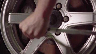 Bir araba tamircisi garaj kutusunda araba lastiği nut.4k,30fps sıkılaştırmak için bir şok anahtarı kullanarak çekleri sıkılaştırır.