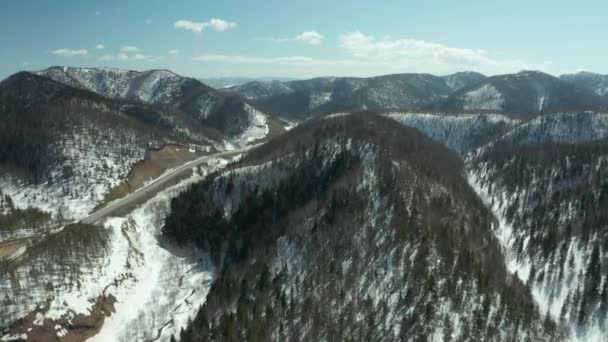 Vue aérienne de la forêt en hiver par une journée ensoleillée avec beaucoup de neige, vue aérienne de la route vers la route dans les collines .
