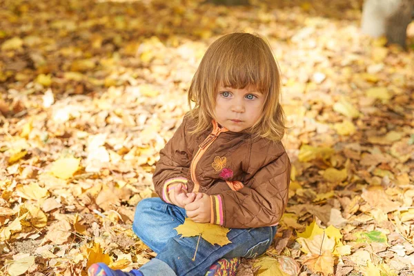 Mädchen mit Eichel und buntem Blatt im Herbstpark. — Stockfoto