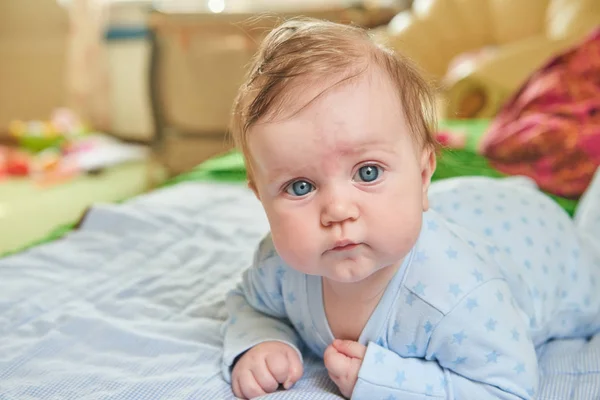 Niedliches Baby auf blauem Bettzeug. — Stockfoto