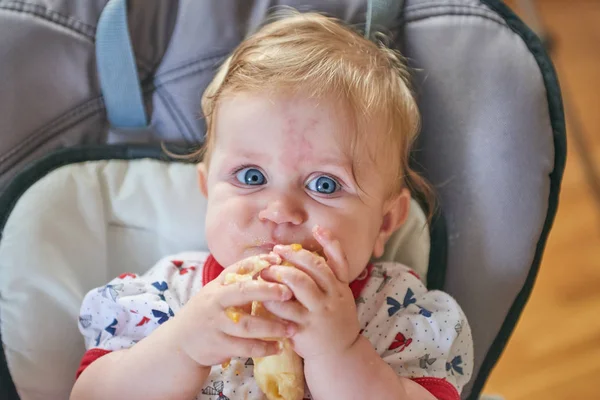 Bebê loiro comendo banana — Fotografia de Stock