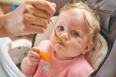 küçük çocuk bir sandalyede oturur