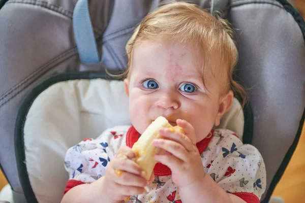 Bebé rubio comiendo plátano — Foto de Stock