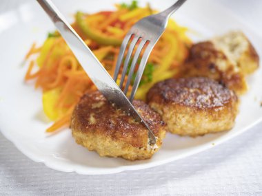 köfte ile sebze, köfte, salata, havuç, kırmızı biber, kuşkonmaz, bıçak ve çatal.