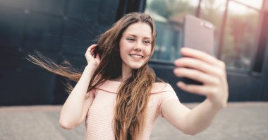 Bir selfie çekerken gülümseyen genç kız