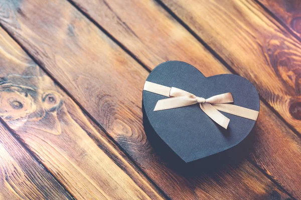 Подарункова коробка у формі чорного серця на старому дереві — стокове фото