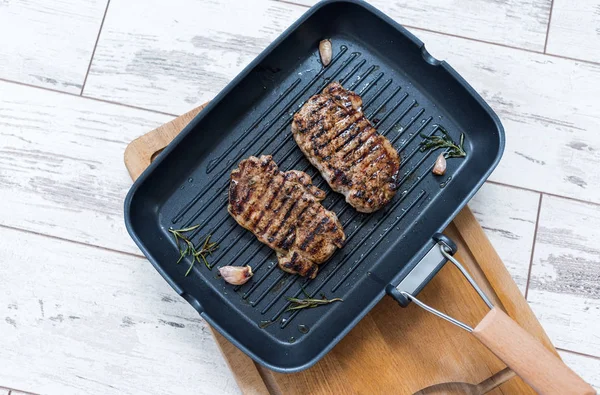 Zwei gegrillte Steaks auf einer Grillpfanne. Ansicht von oben. — Stockfoto