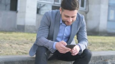 Gülümseyen ve memnun bir işadamı bir smartphone kullanarak