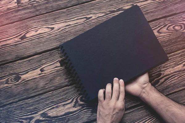 El hombre va a abrir un folleto negro en blanco . — Foto de Stock