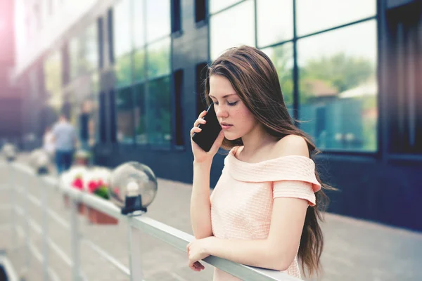 Teenage girl talking serious by a smartphone — Stock Photo, Image