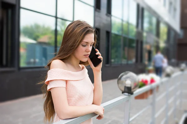 Teenage girl talking serious by a smartphone — Stock Photo, Image