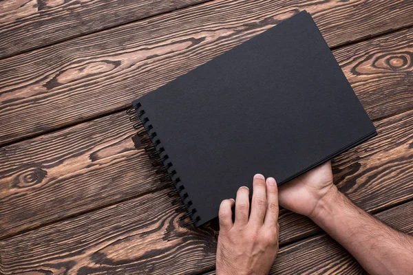 El hombre va a abrir un folleto negro en blanco . — Foto de Stock