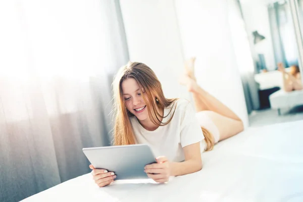 Adorabile teen divertirsi in un letto con il PC digitale — Foto Stock