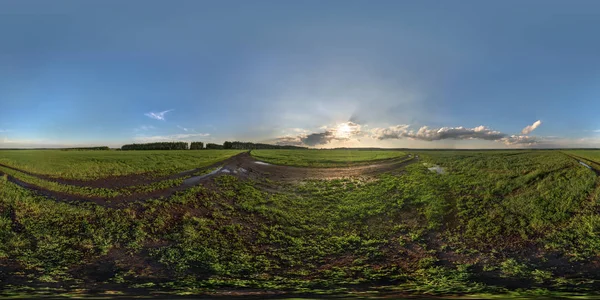 gün batımında küresel panorama, yeşil bir alanda, güneş ışınları ve bulutlar ile. Etrafında büyük bir alan.