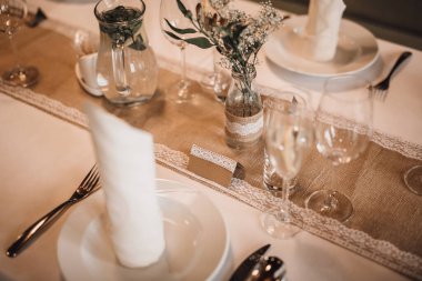 Kırsal tarzda, masa örtüsü, masa örtüsü ve beyaz dantelli bir set masasının ayrıntıları. Sığ alan derinliğinde bir görüntü. Boş misafir etiketine odaklan (metin eklenebilir).