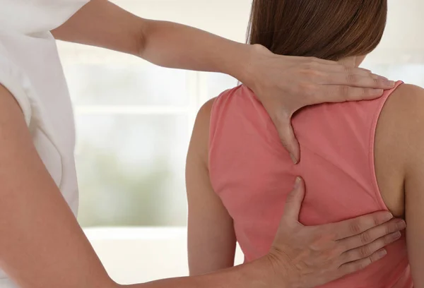 Woman having chiropractic back adjustment. Osteopathy, Physiotherapy, sport injury rehabilitation concept