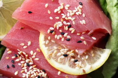 Çiğ ton balığı sashimi, siyah ve beyaz susam ile dekore edilmiş, sağlıklı beslenme konsepti