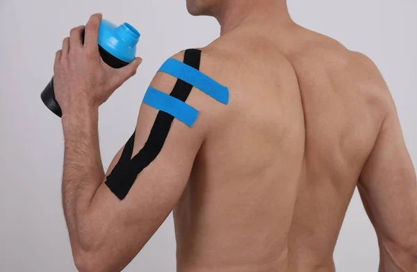 Kinesiology taping. Sport man exercising injury, shoulder pain. Alternative medicine concept — Stock Photo, Image