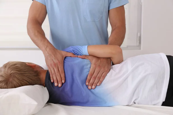 Chico con ajuste de espalda quiropráctico. Osteopatía, Fisioterapia y Kinesiología para niños. Corrección de mala postura — Foto de Stock