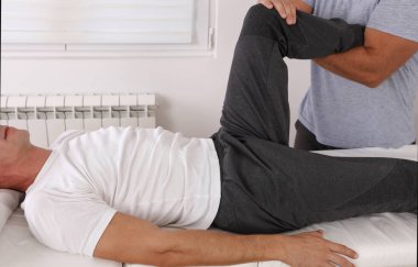 Osteopati tedavisi. Terapist sporcu erkek hastanın yaralı diz tedavisi . Spor fizik tedavi kavramı