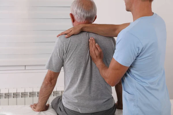 Tratamiento quiropráctico / osteopatía, Alivio del dolor de espalda. Fisioterapia para el paciente masculino mayor, recuperación de lesiones deportivas, Kinesiología — Foto de Stock