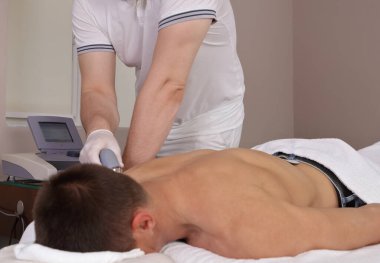 Sırt ağrısı için ultrason terapisi. Fizyoterapist ve erkek hasta