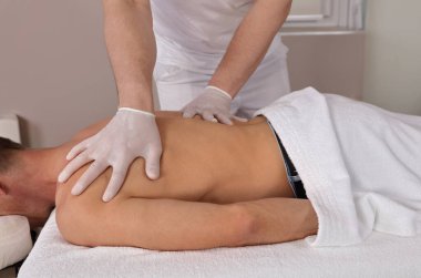 Kas Adam Kayropraktik sırt ayarlaması yaptırıyor. Sırt ağrısı giderici, sakat rehabilitasyon. COVID-19 salgını sırasında güvenlik protokollerini takip eden fizyoterapi