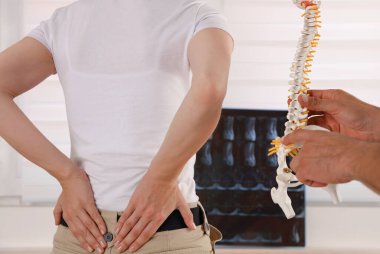 Sırt ağrısı, sinir sıkışması. Doktor Kayropraktik kadın hastaya sırt ağrısının nedenini açıklıyor.
