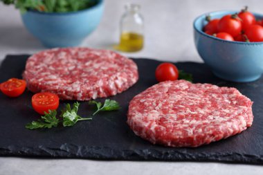 Çiğ hamburgerler kithcen masasında. Yemek fotoğrafçılığı, aşçılık konsepti