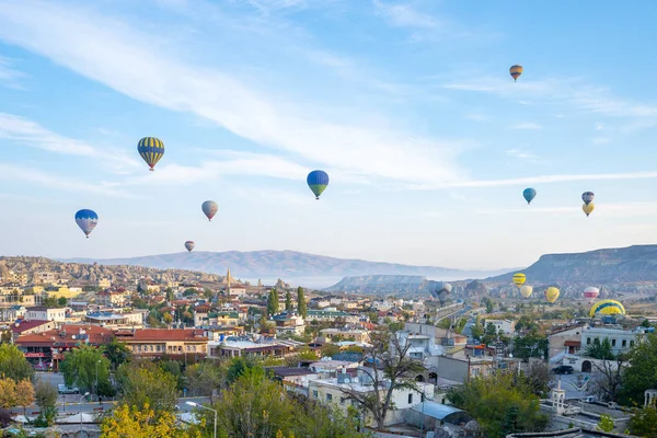 De skyline van de stad van Cappadocië met hete luchtballon zijn rijden in de hemel — Stockfoto