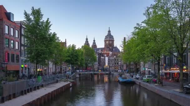 アムステルダムの運河と夜のスカイラインとアムステルダム市の聖ニコラス教会の時間の経過 オランダ — ストック動画