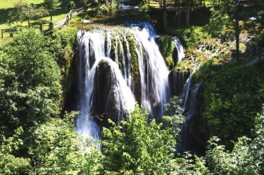 Önünde Korana, ağzına Slunjcica, nehir rapids ve göletler yeşil, traverten engelleri aracılığıyla şelaleler azgın ortasında bir akışı formları.