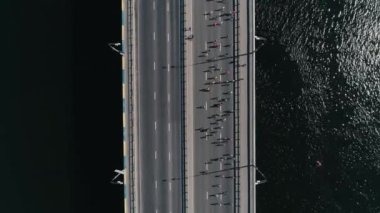Köprüde çalışan maraton. Dikey dolly üstten görünüm yavaş vurdu