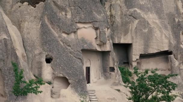 4k 镜头游客们走进岩石里的房子。手持摄像机 — 图库视频影像