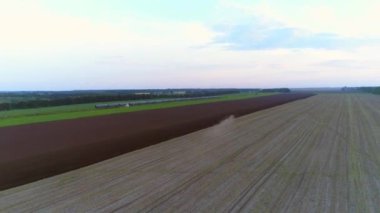 4 k hava dron görüntüleri. Traktör alan çiftçilik. Tren ile arka plan