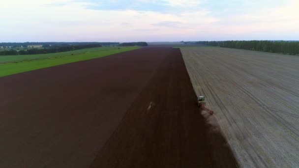 Imágenes aéreas de aviones no tripulados 4K. Campo de arado del tractor. Siguiendo gran ángulo — Vídeos de Stock