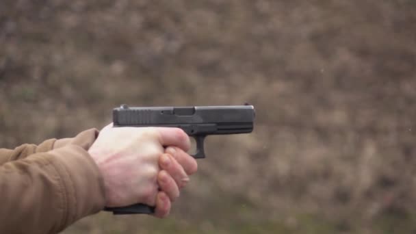 Lentamente filmati. Uomo che spara dalla pistola nera . — Video Stock