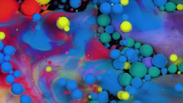 Amazing multicolored bubbles of paint on the oil surface. Paint in oil. — Stock Video