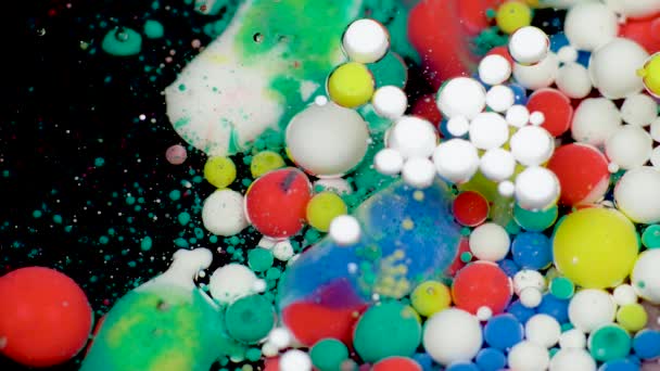 Amazing multicolored bubbles of paint on the oil surface. Paint in oil. — Stock Video