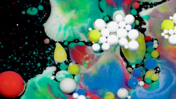 Amazing multicolored bubbles of paint on the oil surface. Paint in oil. — Stock Video