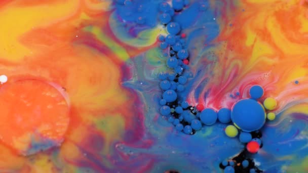 Amazing multicolored bubbles of paint on the oil surface. Paint in oil. — Stock Video