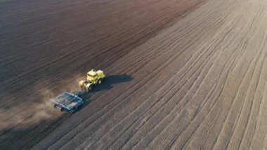 Büyük kahverengi alanda Traktör ekim için toprak hazırlar.