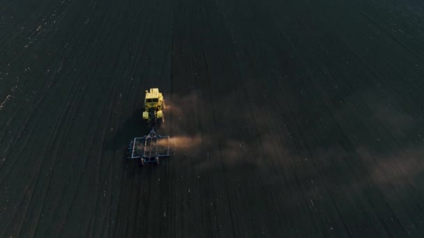 Tracteur dans le grand champ brun prépare le sol pour l'ensemencement . — Video