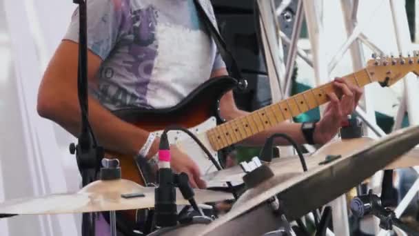 Κιθαρίστας παίζοντας μια ηλεκτρική κιθάρα σε ένα ροκ μπάντα κατά τη διάρκεια μιας ζωντανής απόδοσης εστιάζοντας πίσω στο φόντο — Αρχείο Βίντεο