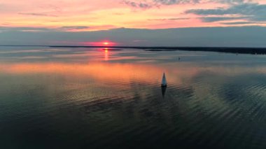 Yat alacakaranlıkta sakin suda seyir ile huzurlu sahnenin havadan drone görüntüleri.