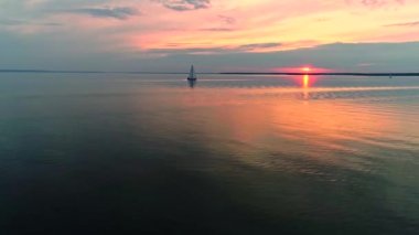 Yat alacakaranlıkta sakin suda seyir ile huzurlu sahnenin havadan drone görüntüleri.