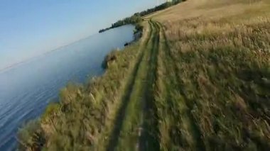 Fpv Drone yarış görünümü. Alan ve toprak yol ile kıyı şeridi üzerinde fly